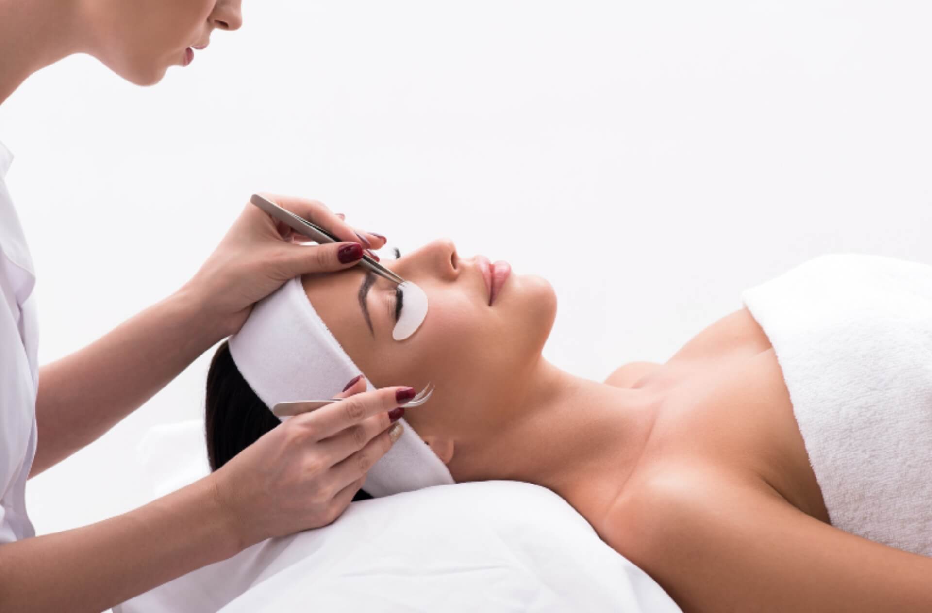 woman receiving eyelash extensions at day spa